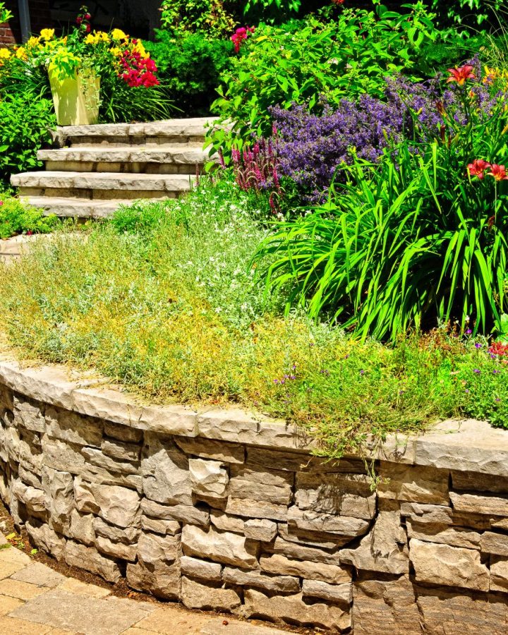Natural stone landscaping in home garden with stairs and retaining walls
